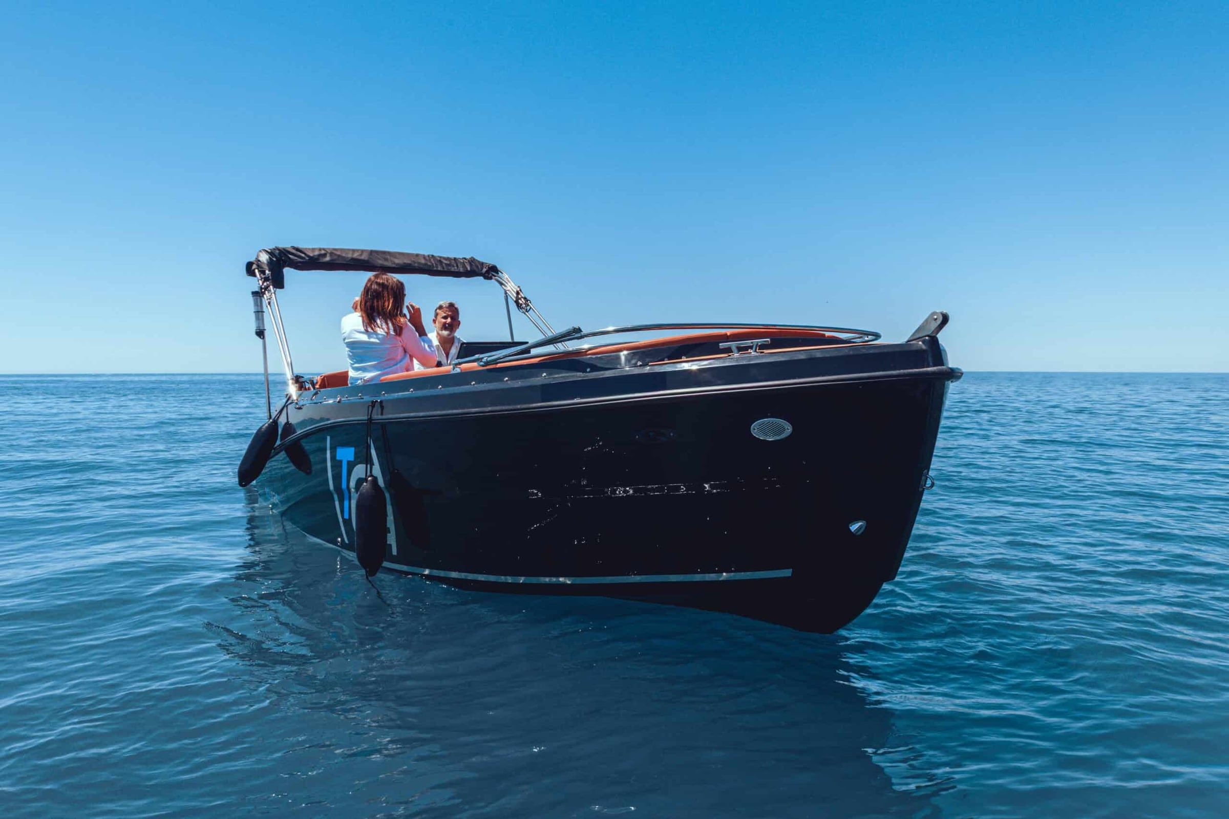 El Nassau III, casco oscuro y tapizado naranja, navegando